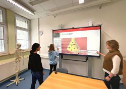 Grit Haufe (r.i.B.) und zwei Schülerinnen am Smartboard. Die stellvertretende Schulleiterin des OSZ Wittenberge nutzt die neuen digitalen Displays  für eine interaktive Unterrichtsgestaltung und eine moderne Form der Wissensvermittlung. (Foto: LK Prignitz)