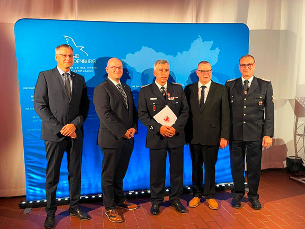 Der Pritzwalker Ortswehrführer Adrian Zechser (M.) erhielt die Auszeichnung von Brandenburgs Innenminister Michael Stübgen (2.v.r.). Zu den ersten Gratulanten gehörten der Prignitzer Landrat Christian Müller (2.v.l.), der Sachbereichsleiter Brand- und Katastrophenschutz beim Landkreis Prignitz, Marcus Bethmann (l.), sowie der Prignitzer Kreisbrandmeister Holger Rohde (r.). Foto: Landkreis Prignitz