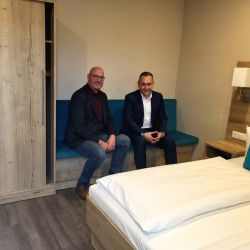 Christian Langer (Geschäftsführer Neuer Hennings Hof) und Mike Laskewitz (Geschäftsführer Tourismusverband Prignitz) in einem modernisierten Zimmer im Neuen Hennings Hof / Foto: Tourismusverbnad Prignitz